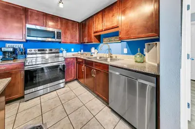 a kitchen with wooden cabinets and stainless steel appliances at Laketown Wharf 927 in Panama City Beach