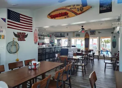 a restaurant with tables and chairs and an american flag on the wall at Gulf Highlands Beach Townhouse in Panama City Beach