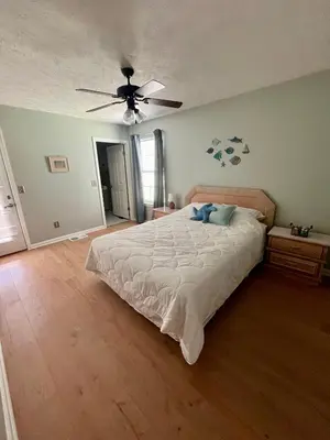 a bedroom with a bed and a ceiling fan at Cozy Two-Bedroom Cottage-5min walk to beach! in Panama City Beach