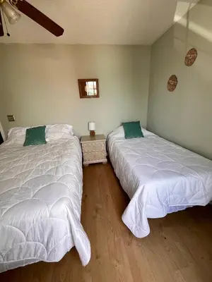 two beds sitting next to each other in a bedroom at Cozy Two-Bedroom Cottage-5min walk to beach! in Panama City Beach
