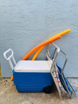 a luggage cart with an orange umbrella and tooth brushes at Cozy Two-Bedroom Cottage-5min walk to beach! in Panama City Beach