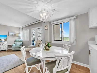 a dining room and living room with a table and chairs at Pinnacle Port A-305 in Panama City Beach