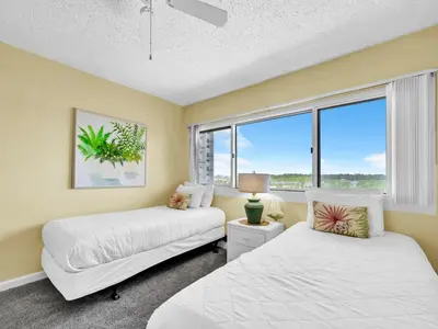 two beds in a room with a window at Pinnacle Port A-305 in Panama City Beach