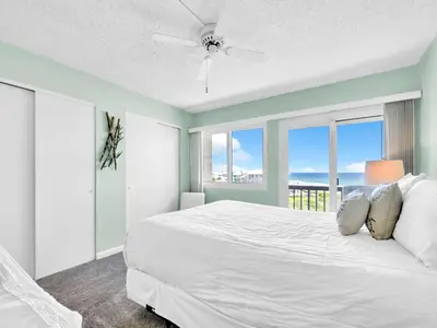 a bedroom with a white bed with a view of the ocean at Pinnacle Port A-305 in Panama City Beach