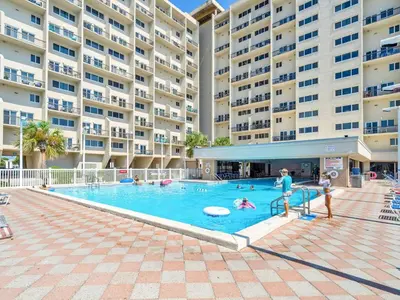 a swimming pool with people in a large apartment building at Pinnacle Port A-305 in Panama City Beach