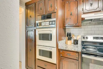 a kitchen with wooden cabinets and white appliances at Walk to Ocean Home in Panama City Beach! in Panama City Beach