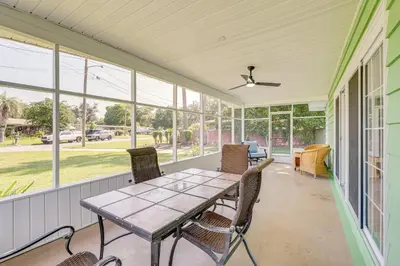 a screened in porch with a table and chairs at Walk to Ocean Home in Panama City Beach! in Panama City Beach