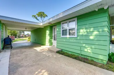a green house with a chair in front of it at Walk to Ocean Home in Panama City Beach! in Panama City Beach