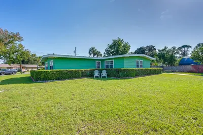 a green house with two chairs in a yard at Walk to Ocean Home in Panama City Beach! in Panama City Beach