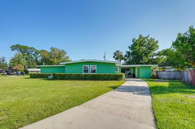a green house with a sidewalk in front of it at Walk to Ocean Home in Panama City Beach! in Panama City Beach