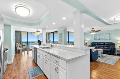 a kitchen and living room with a view of the ocean at Pelican Walk 1012 in Panama City Beach