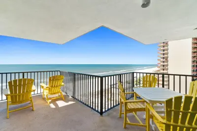 a balcony with a table and chairs and the ocean at Pelican Walk 1012 in Panama City Beach
