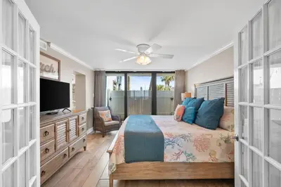 a bedroom with a bed and a flat screen tv at Pelican Walk 101 in Panama City Beach