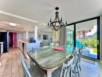 a dining room with a glass table and chairs at Pelican Walk 101 in Panama City Beach