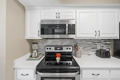 a kitchen with a stove and a microwave at Pelican Walk 101 in Panama City Beach