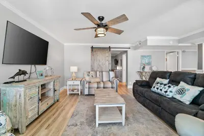 a living room with a couch and a flat screen tv at Pelican Walk 308 in Panama City Beach