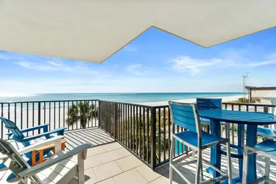 a balcony with chairs and tables and the ocean at Pelican Walk 308 in Panama City Beach