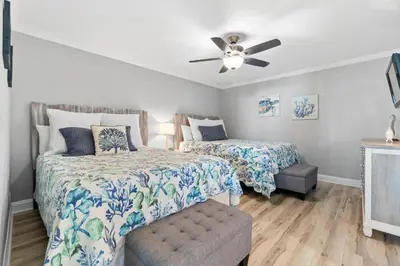 a bedroom with two beds and a ceiling fan at Pelican Walk 308 in Panama City Beach