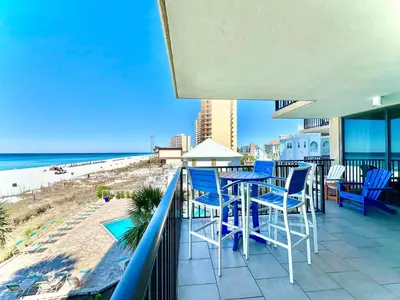 a balcony with a table and chairs and the beach at Pelican Walk 308 in Panama City Beach