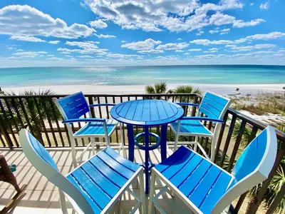 a table and chairs on a balcony with the beach at Pelican Walk 308 in Panama City Beach