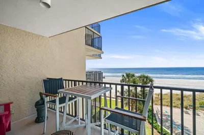 a balcony with a table and chairs and the beach at Pelican Walk 309 in Panama City Beach