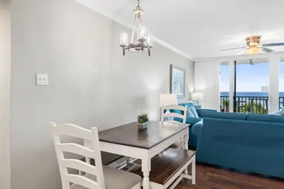 a dining room with a table and blue chairs at Pelican Walk 309 in Panama City Beach