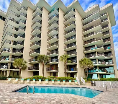 a large apartment building with a pool in front of it at Pelican Walk 309 in Panama City Beach