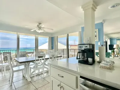 a kitchen and dining room with a view of the ocean at Pelican Walk 312 in Panama City Beach