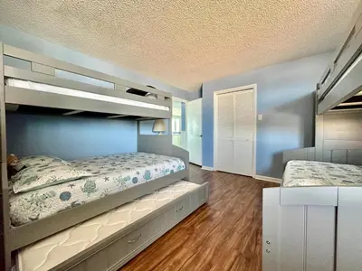 two beds in a bedroom with blue walls at Pelican Walk 312 in Panama City Beach