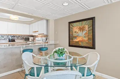 a dining room with a glass table and chairs at Pelican Walk 204 in Panama City Beach