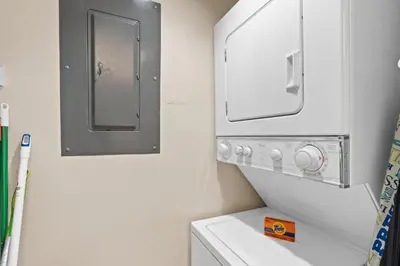 a small bathroom with a washing machine and a mirror at Pelican Walk 204 in Panama City Beach