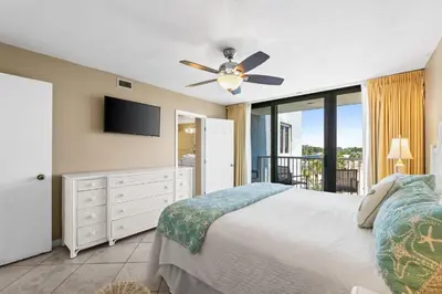 a bedroom with a bed and a ceiling fan at Pelican Walk 401 in Panama City Beach