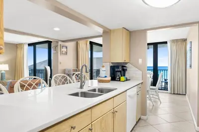 a kitchen with a sink and views of the ocean at Pelican Walk 401 in Panama City Beach