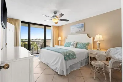 a bedroom with a bed and a balcony at Pelican Walk 401 in Panama City Beach