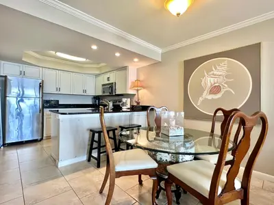a kitchen with a glass table and a dining room at Pelican Walk 102 in Panama City Beach