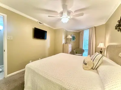 a bedroom with a bed and a ceiling fan at Pelican Walk 102 in Panama City Beach