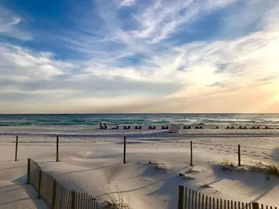 a beach with a fence and the ocean at Pelican Walk 102 in Panama City Beach