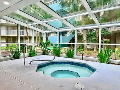 an indoor swimming pool in a building with a glass ceiling at Pelican Walk 102 in Panama City Beach