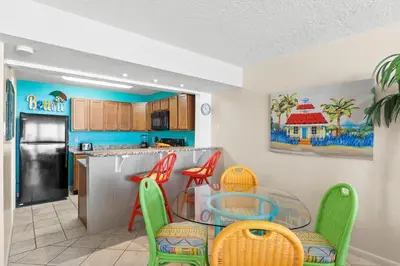 a kitchen with a table and chairs in a kitchen at Pelican Walk 404 in Panama City Beach
