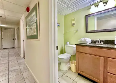 a bathroom with a toilet and a sink and a mirror at Pelican Walk 404 in Panama City Beach