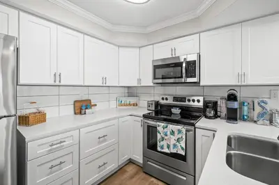 a kitchen with white cabinets and a stove top oven at Pelican Walk 403 in Panama City Beach