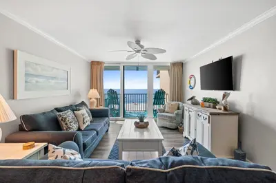 a living room with a couch and a tv at Pelican Walk 403 in Panama City Beach