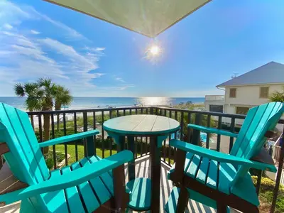 a table and chairs on a balcony with the ocean at Pelican Walk 209 in Panama City Beach