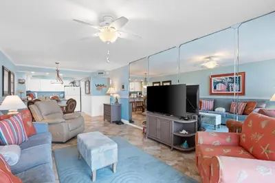 a living room with couches and a flat screen tv at Pelican Walk 209 in Panama City Beach