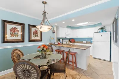 a kitchen and dining room with a table and chairs at Pelican Walk 209 in Panama City Beach