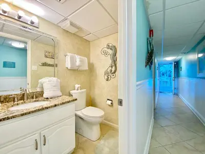 a bathroom with a toilet and a sink and a mirror at Pelican Walk 209 in Panama City Beach