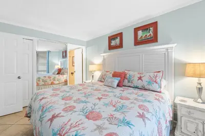 a bedroom with a bed with a floral bedspread at Pelican Walk 209 in Panama City Beach