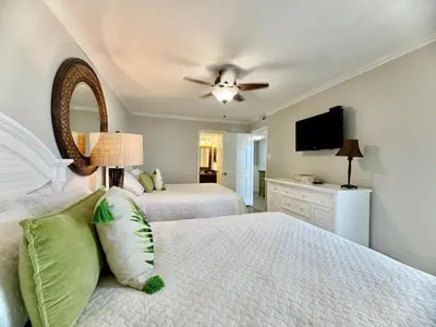 a bedroom with two beds and a ceiling fan at Pelican Walk 512 in Panama City Beach