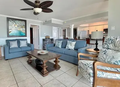 a living room with blue couches and a table at Pelican Walk 512 in Panama City Beach
