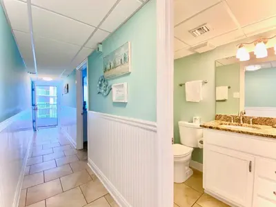 a bathroom with a toilet and a sink and a mirror at Pelican Walk 504 in Panama City Beach